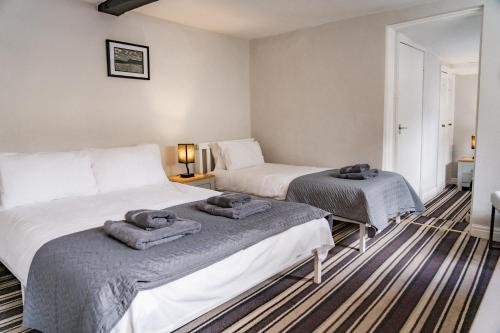 two beds in a room with towels on them at The Court in Bridgnorth