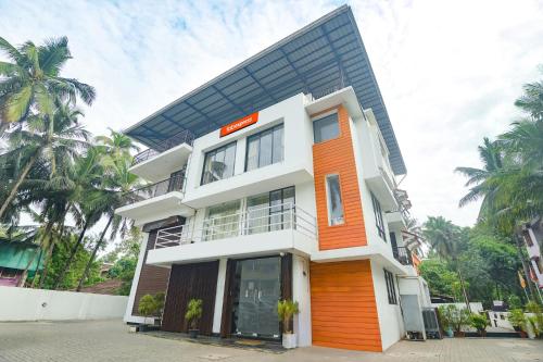 una casa con facciata arancione e bianca di FabExpress Holiday Suites - Nr Benaulim Beach a Benaulim