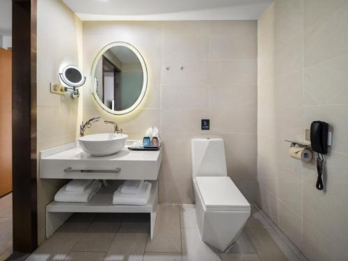 a bathroom with a sink and a toilet and a mirror at Lavande Hotel Chengdu Tianfu Square in Chengdu