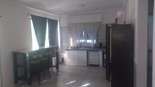 a kitchen with a refrigerator and a table with chairs at CasaClubDescanso in General Rodríguez
