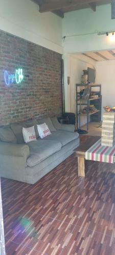 a living room with a couch and a brick wall at CasaClubDescanso in General Rodríguez