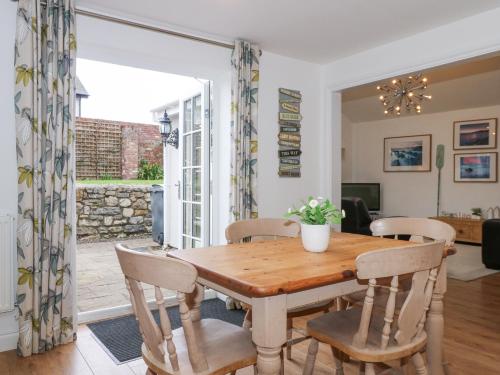 a dining room with a wooden table and chairs at Pippin Cottage in Beaumaris