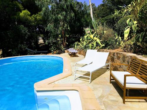 une piscine avec deux chaises et une piscine dans l'établissement Superb sea view villa with pool and big garden, à Pietrosella