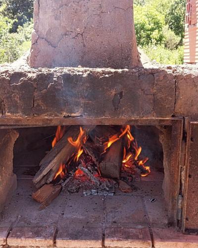 a brick oven with a fire inside of it at CasaClubDescanso in General Rodríguez