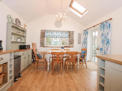 a kitchen and dining room with a table and chairs at Bramley Cottage in Beaumaris