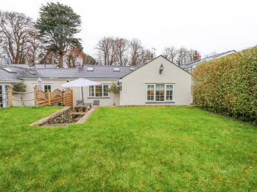 a white house with a lawn in front of it at Bramley Cottage in Beaumaris