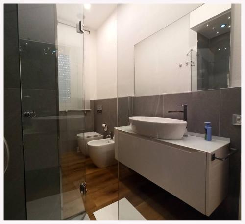 a bathroom with a sink and a toilet and a mirror at Carneval and Tuscany in Viareggio