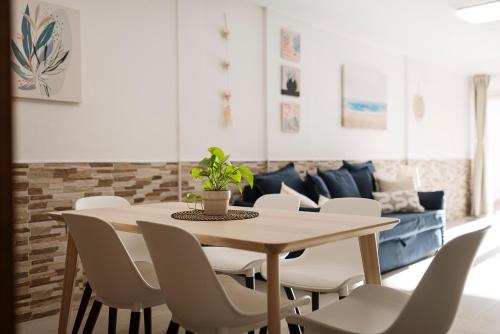 a dining room with a table and chairs and a couch at Apartamento Vientos de Duna y Luna in Playa Honda