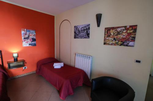 a bedroom with orange walls and a bed and a chair at Antica Dimora in Palermo