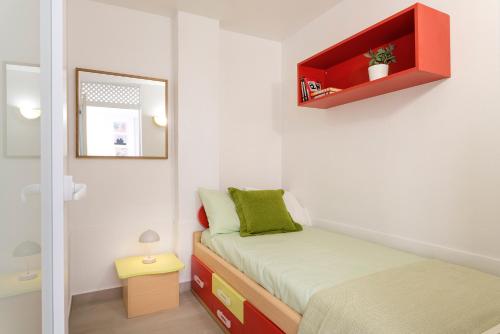 a small bedroom with a bed and a mirror at Apartamento Vientos de Duna y Luna in Playa Honda