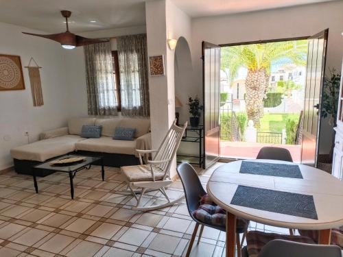 een woonkamer met een bank en een tafel bij Bungalow con vistas a la piscina in Torrevieja
