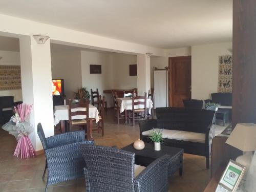 a living room with chairs and a dining room at Hotel Plammas in Santa Maria Navarrese