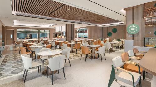 a rendering of a restaurant with tables and chairs at EVEN Hotel Wuhan Airport Zone by IHG in Wuhan