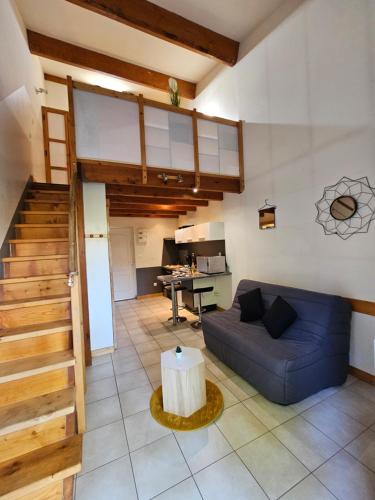 un salon avec un canapé bleu et une table dans l'établissement Gîte Les Mirabelliers L'Escapade Des Flamants Roses, à Mireval