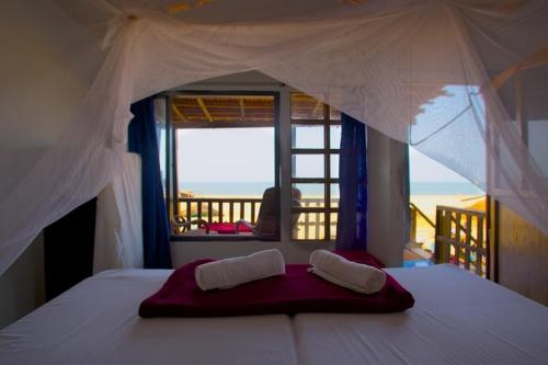 Schlafzimmer mit einem Bett und Meerblick in der Unterkunft Om Shanti Beach Stay Patnem in Patnem