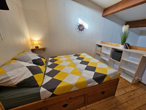 une chambre avec un lit avec une couverture à carreaux dans l'établissement Gîte Les Mirabelliers L'Escapade Des Flamants Roses, à Mireval