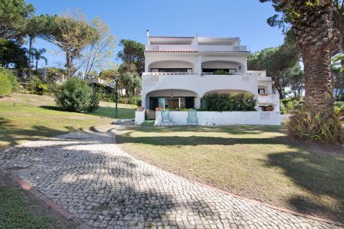 a large white house with a tree in front of it at Celestial Blue Vale Do Lobo in Almancil