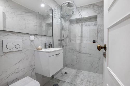 a white bathroom with a shower and a sink at Celestial Blue Vale Do Lobo in Almancil