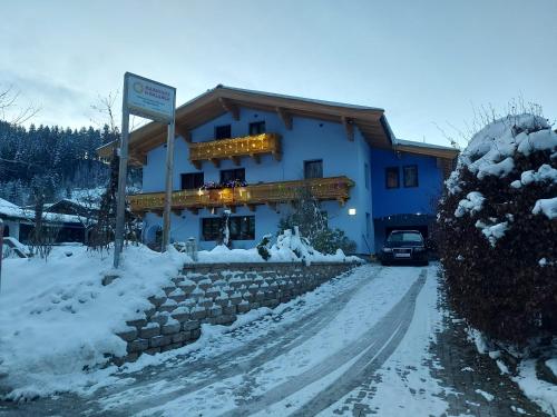 a large blue building with a sign in the snow at Appartement Harmonie & Balance in Leogang