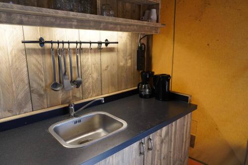 a kitchen counter with a sink and utensils at Veluwe buitenverblijf op de Glamping voor 6 personen LL55 in Putten