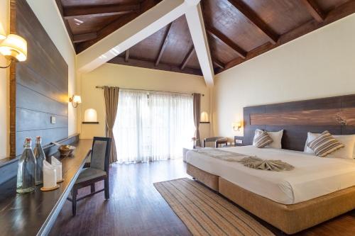 a bedroom with a large bed and a window at Jungle Villa Resort - Near Chitwan National Park in Chitwan