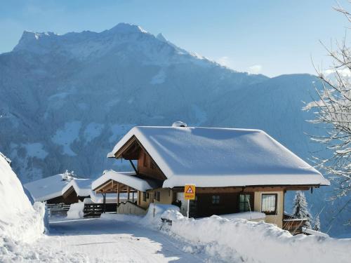 a house covered in snow with mountains in the background at Holiday Home Reichegger by Interhome in Grün