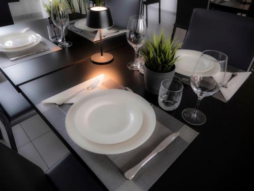a black table with a white plate and glasses on it at Loto Business Hotel in Rome