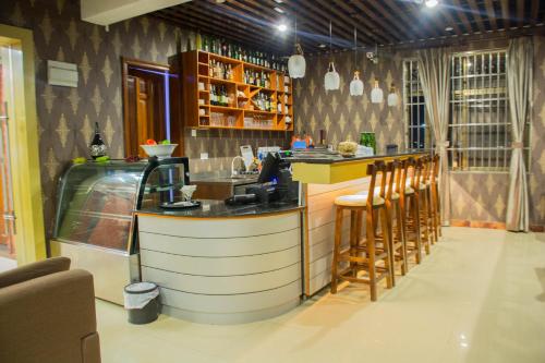 een restaurant met een bar met krukken bij Hong Kong Hotel in Dar es Salaam