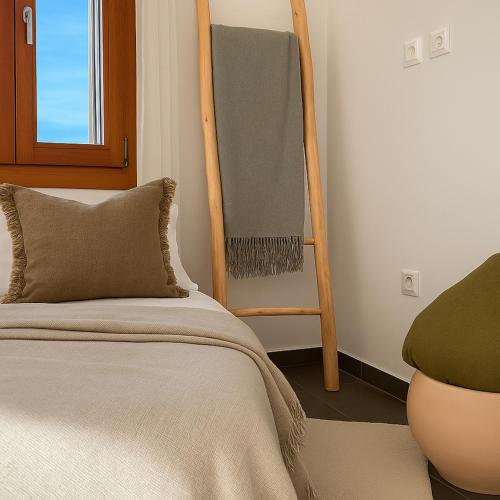 a bedroom with a bed and a wooden ladder at Epidavros View Villas in Ancient Epidavros