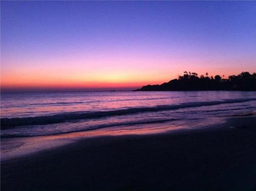 a sunset on a beach with the ocean at Om Shanti Beach Stay Patnem in Patnem