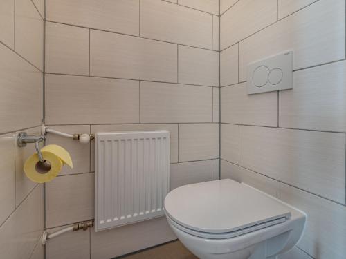 a bathroom with a white toilet and a toilet paper dispenser at Apartment Ferienglück by Interhome in Arriach