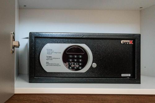 a small black microwave with a tv on a wall at TESLA Residence Subotica in Subotica