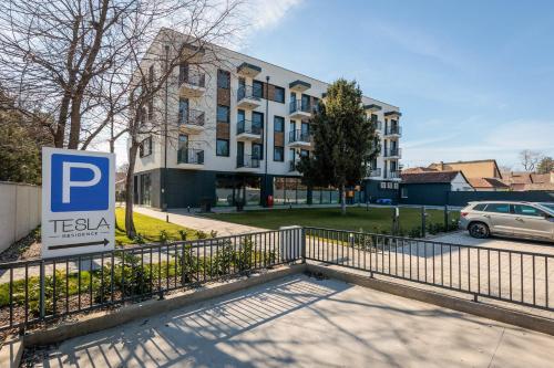 a parking sign in front of a building with a parking lot at TESLA Residence Subotica in Subotica