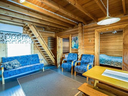 een woonkamer met een blauwe bank en twee stoelen bij Holiday Home Illankajo by Interhome in Suninsalmi