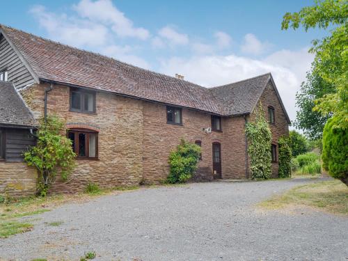 a brick house with a driveway in front of it at The Cider House in Bredenbury