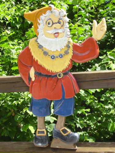 a statue of a clown sitting on a bench at Zwergerlhof in Loich