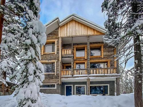 une maison en rondins dans la neige avec des arbres dans l'établissement Holiday Home Pyhän kivi by Interhome, à Pyhätunturi