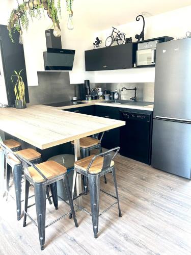 a kitchen with a large wooden table and chairs at L'Industriel in Quincieux