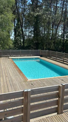 - une piscine sur une terrasse en bois avec une clôture dans l'établissement Havre de paix familial & piscine - L'Instant Clef, à Guécélard