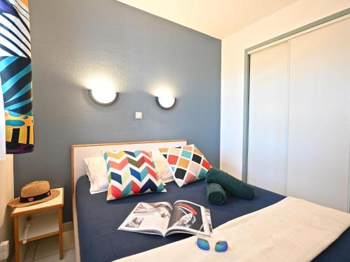 - une chambre avec un lit et un livre dans l'établissement Apartment Le Hameau - L2 202 by Interhome, à Agay