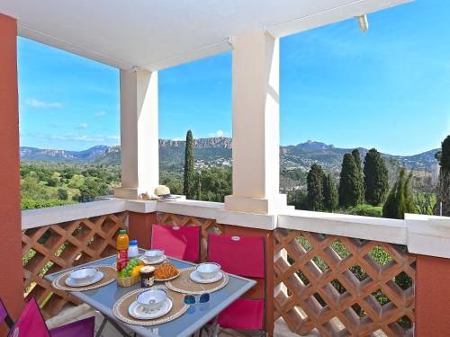 une table sur un balcon avec vue sur les montagnes dans l'établissement Apartment L'Esquinade - G1 103 by Interhome, à Agay