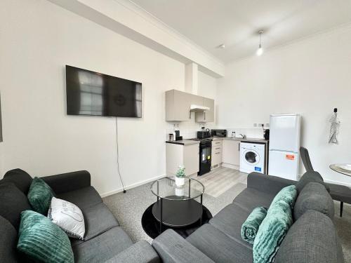a living room with a couch and a kitchen at City Haven - 2 Bed in Sheffield - LuxeSuites in Midland