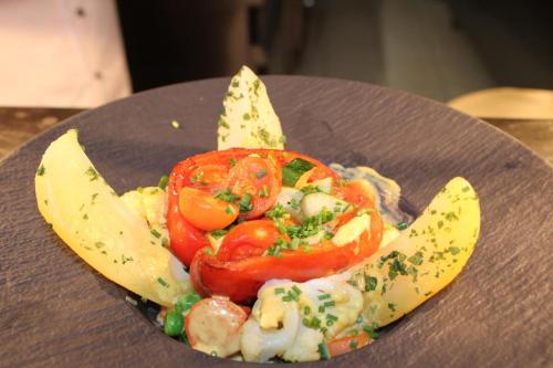 a plate of food with tomatoes and a banana at Hotel & Residence Hochriegel in Spiegelau