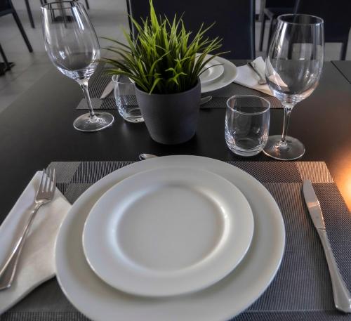 a table with white plates and glasses and a plant at Loto Business Hotel in Rome