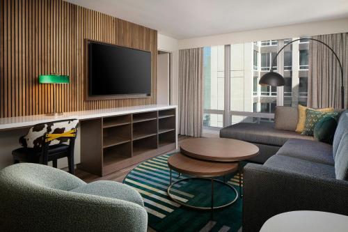 a living room with a couch and a tv at Le Meridien Fort Worth Downtown in Fort Worth
