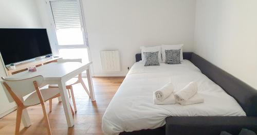 une chambre avec un lit, un bureau et une télévision dans l'établissement Near Rempart - Wifi - Quiet and comfortable!, à Avignon