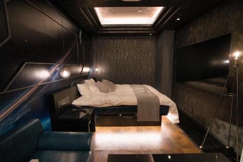 a room with a bed and a couch in it at HOTEL The KAISER -全室人工ラドン温泉- in Kanie