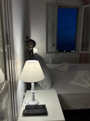 a lamp sitting on a table next to a bed at Villa Rosa in Plomarion