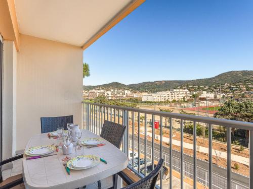 Una mesa en un balcón con vista a una ciudad. en Apartment Les Cyclades-11 by Interhome, en Le Lavandou