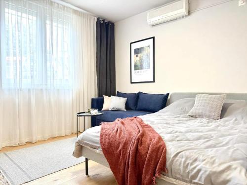 a bedroom with a bed and a blue couch at Studio Apartment 1906 in Mostar